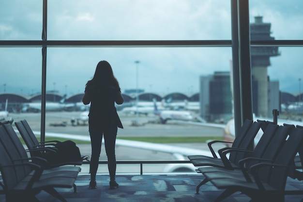 Achteraanzicht beeld van een vrouwelijke reiziger met rugzak op de luchthaven