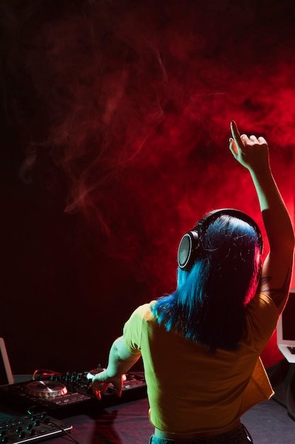 Achteraanzicht DJ vrouw feeststemming instellen