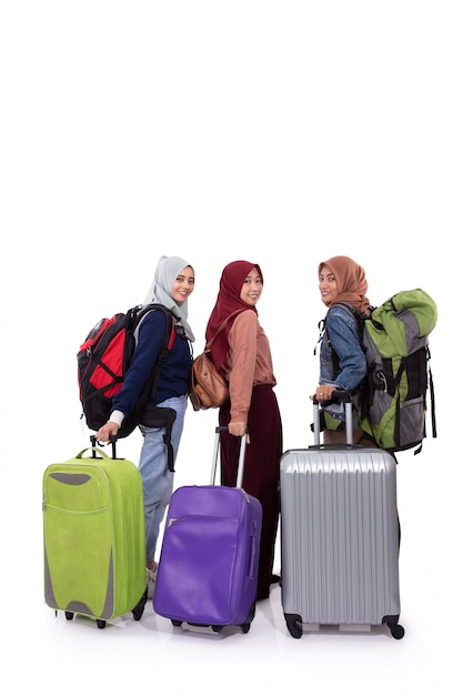 Achteraanzicht, drie hijab vrouw staande houden koffer en draagtas