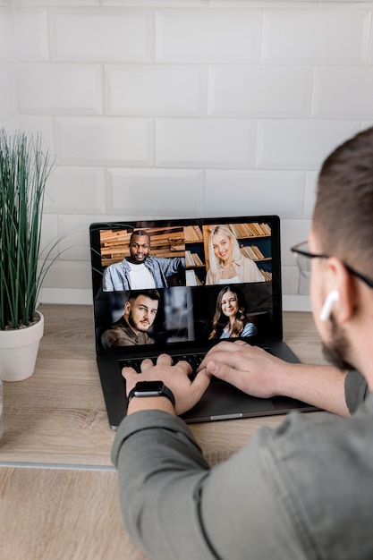 Achteraanzicht een zakenman spreekt op een webconferentie met verschillende collega's met behulp van een laptop-webcam