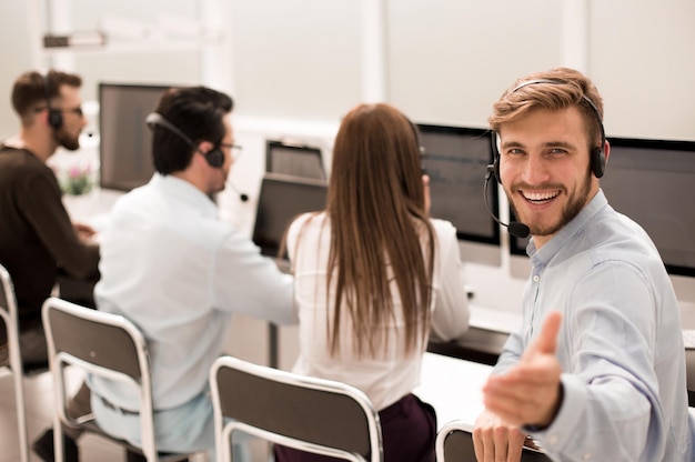 Achteraanzicht jonge klantenservicemedewerker zit aan zijn Deskphoto met kopieerruimte