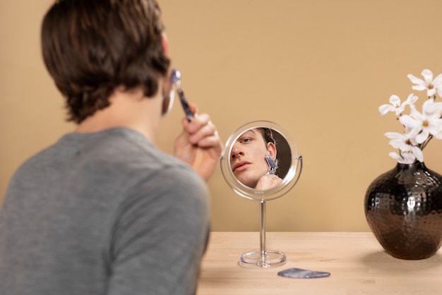 Foto achteraanzicht man met behulp van gua sha tool