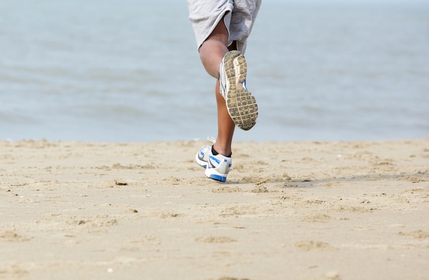 Achteraanzicht mannelijke jogger op het strand