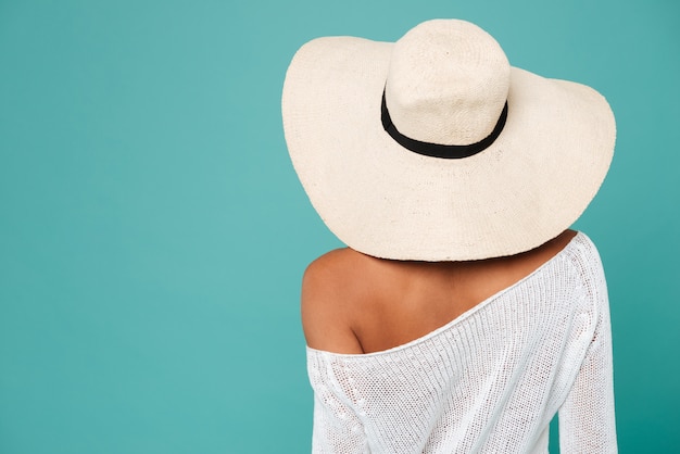 Achteraanzicht van aantrekkelijke jonge vrouw in witte zomer hoed