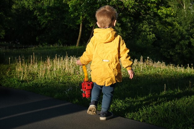 Achteraanzicht van actieve peuterjongen die in de lente buiten loopt