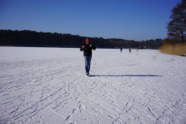 Foto achteraanzicht van de man die op sneeuwveld staat