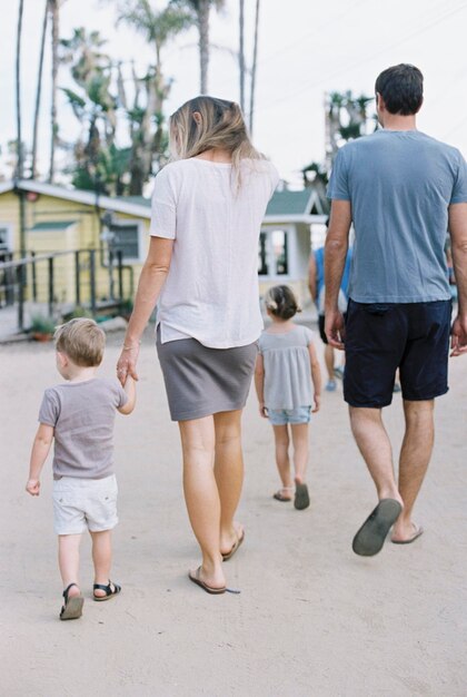 Achteraanzicht van een gezin een paar wandelen met hun jonge zoon en dochter