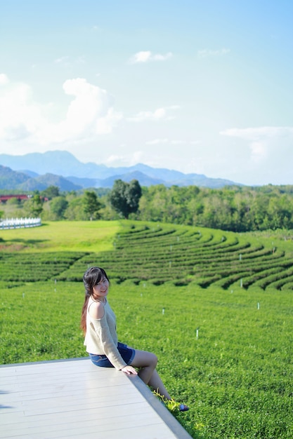 Achteraanzicht van een jonge vrouw die er ook uitziet Choui Fong-theeplantage. - Chiang Rai-Thailand.