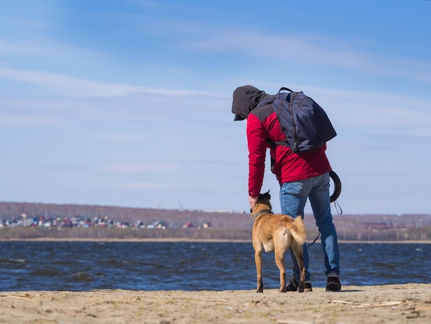 Achteraanzicht van een man die een hond aait uit het asiel