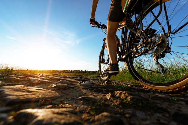 Achteraanzicht van een man met een fiets tegen de blauwe hemel.