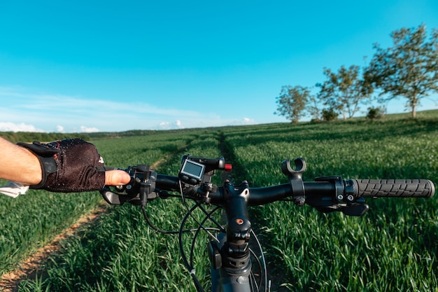 Achteraanzicht van een man met een fiets tegen de blauwe lucht. fietser rijdt op een fiets.