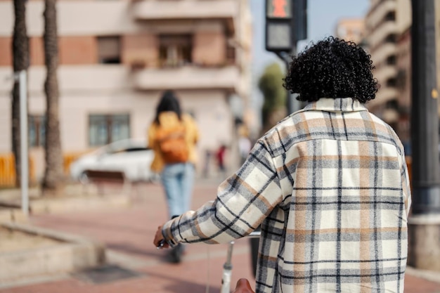 Achteraanzicht van een milieubewuste reiziger die met zijn vriendin op een fiets rijdt