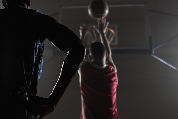 Achteraanzicht van een speler die een basketbal schiet