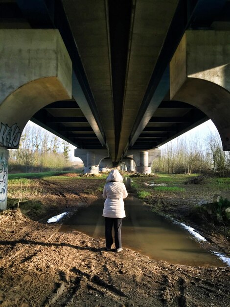 Foto achteraanzicht van een vrouw die onder de brug staat