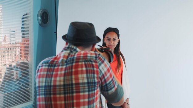 Foto achteraanzicht van fotograaf die foto's maakt van een prachtig multiraciaal model in de studio die ze poseert in...