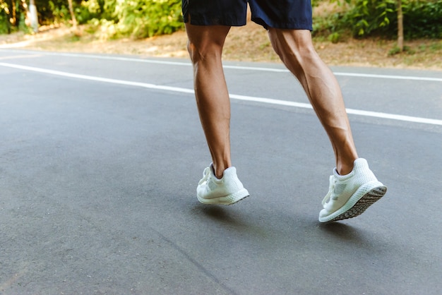 Achteraanzicht van gespierde sportman benen joggen