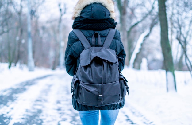 Achteraanzicht van jonge vrouw wandelen in de ongelooflijke winterorest met enorme rugzak