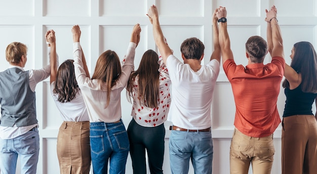 Achteraanzicht van mensen hand in hand. samen zijn we sterker.