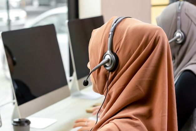 Achteraanzicht van moslim zakenvrouw werken in call center kantoor