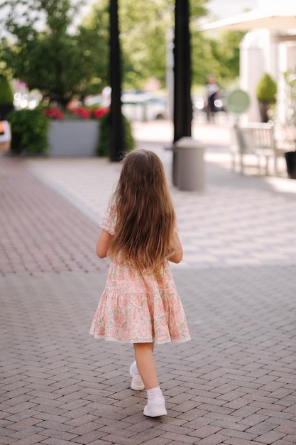 Achteraanzicht van schattig klein meisje op winkelen portret van schattig kind met boodschappentassen