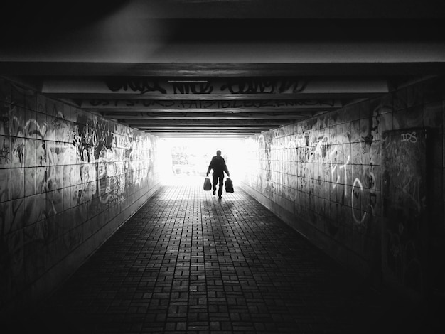Achteraanzicht van silhouetmensen die in de tunnel lopen