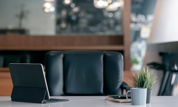 Achteraanzicht van tablet met toetsenbord op tafel in donkere kantoorruimte.