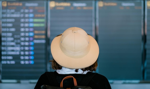 Achteraanzicht van toeristische vluchten in vertrekschermen op de luchthaven