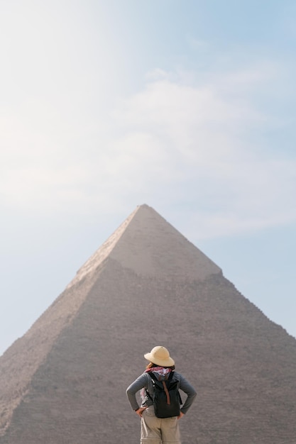 Achteraanzicht van toeristische vrouw die voor een piramide staat Egypte Cairo Giza