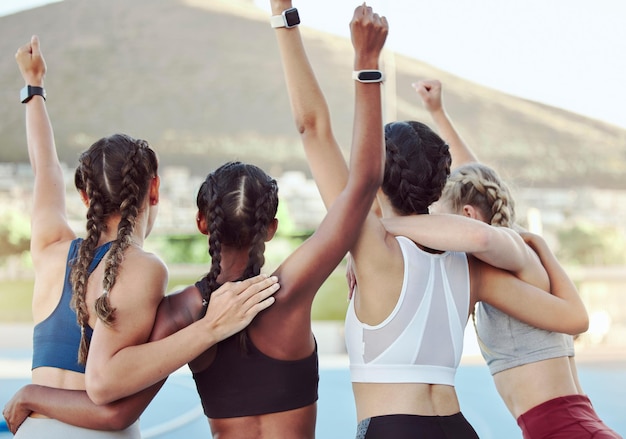 Achteraanzicht van trotse opgewonden Olympische kampioenen die samen in eenheid knuffelen en juichen Actief jong team dat zich verheugt na het winnen van een prestatie Een groep diverse vrouwelijke atleten die de overwinning vieren