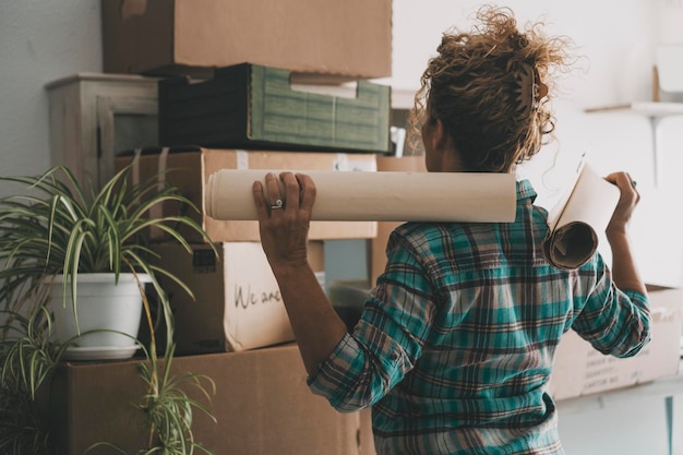 Foto achteraanzicht van vrouw voor veel kartonnen dozen na een bewegende hypothecaire lening nieuw huis en leven vrouwelijke onafhankelijke mensen genieten van platte appartement vrije tijd verhuizing en verhuur concept binnenhuis