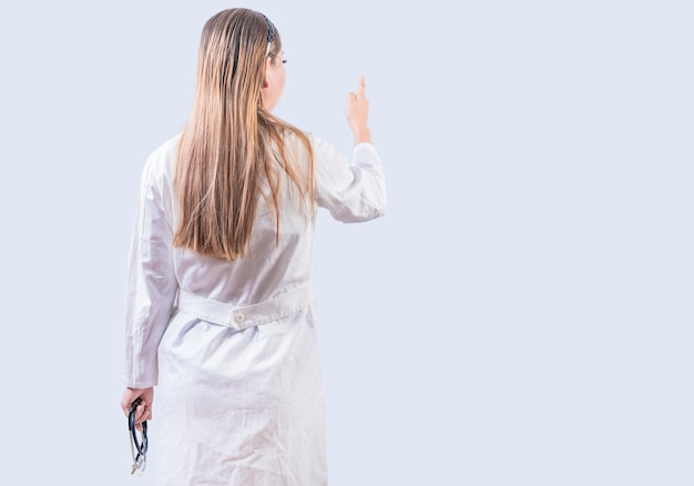 Achteraanzicht van vrouwelijke arts geïsoleerd wijzen Jonge vrouwelijke arts van achter wijzende vinger geïsoleerd