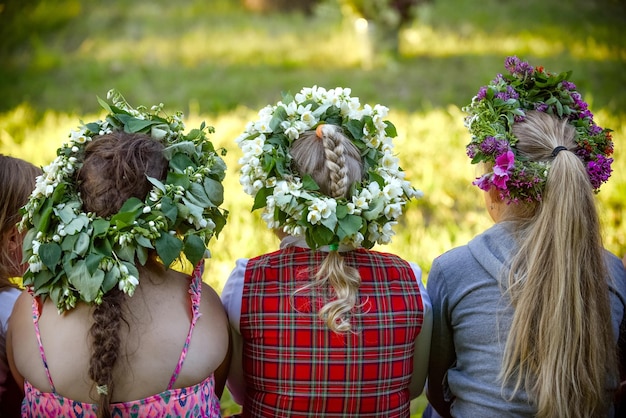 Achteraanzicht van vrouwtjes die traditionele bloemenhoofdtooien dragen voor het Midzomerfestival in Letland