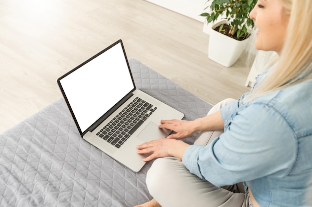 Achteraanzicht van zakelijke vrouw handen bezig met behulp van laptop op kantoor bureau, met copyspace.