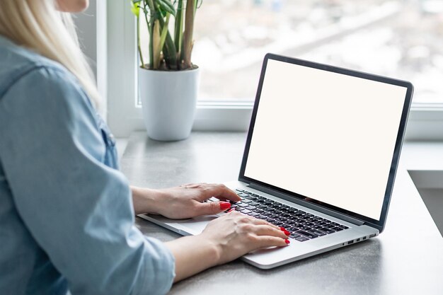 Achteraanzicht van zakelijke vrouw handen bezig met behulp van laptop op kantoor bureau, met copyspace.