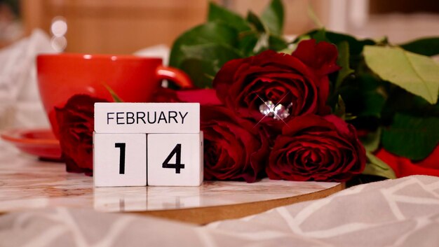 Achtergrond Feestelijke Flatlay-compositie voor Valentijnsdag op 14 februari Koffie in een rode kop roodroze bloemen en diamanten hartoorbellen thuis in bed