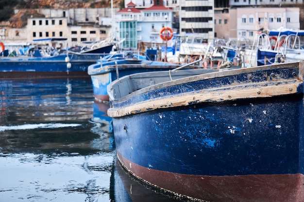 Achtergrond - gedeeltelijk vervaagde kleine blauwe vissersboten in de haven