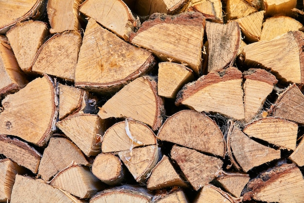 Achtergrond Hout gehakt en gestapeld in een opslagstapel Brandhout verzamelen als energiebron Verschillende maten en vormen van stammen na het vellen van materialen voor gereedschap en beschutting van bovenaf