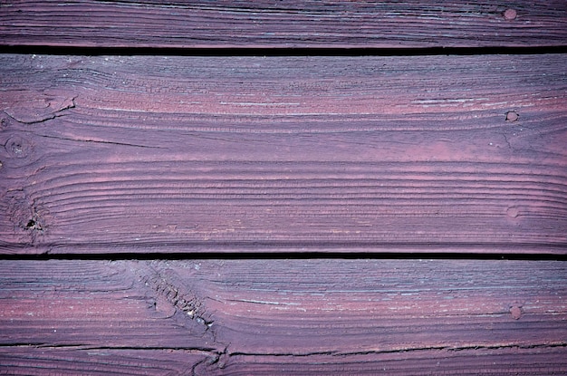 Achtergrond houten oppervlak met scheuren op de oude verf van violet kleur houtstructuur close-up vignettering