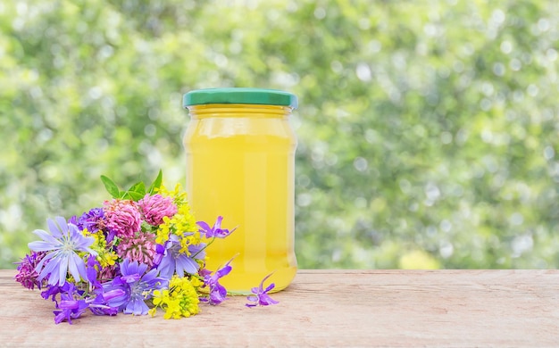 Achtergrond met een pot honing en een boeket wilde bloemen met kopieerruimte