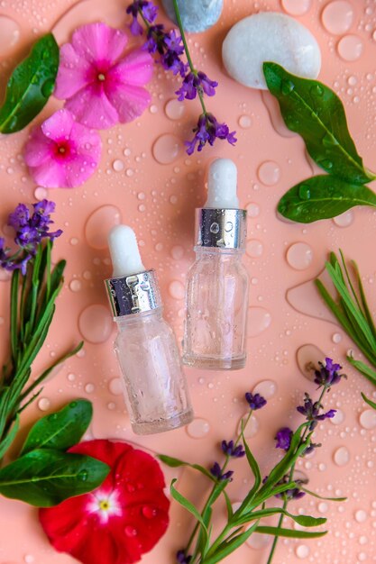 Achtergrond met waterdruppels cosmetica in een fles en bloemen Hyaluronzuur Selectieve focus