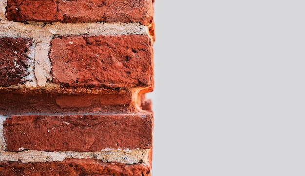 Achtergrond of textuur van een rode bakstenen muur en een deel van een lichtgrijze betonnen muur in hoge resolutie Close-up met kopie ruimte voor tekst Idee voor reclamebanner of productartikel