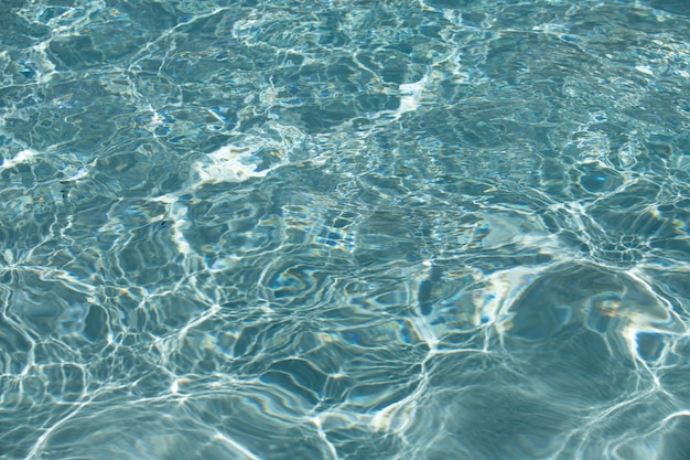Achtergrond van blauw water in zwembad met zonreflectie rimpelwatergolf in zwembad helder water