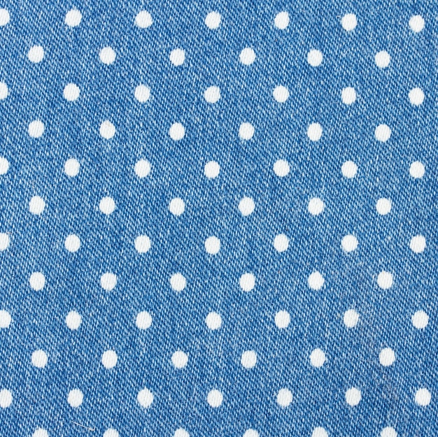 Achtergrond van blauwe spijkerbroek met wit polka dot patroon