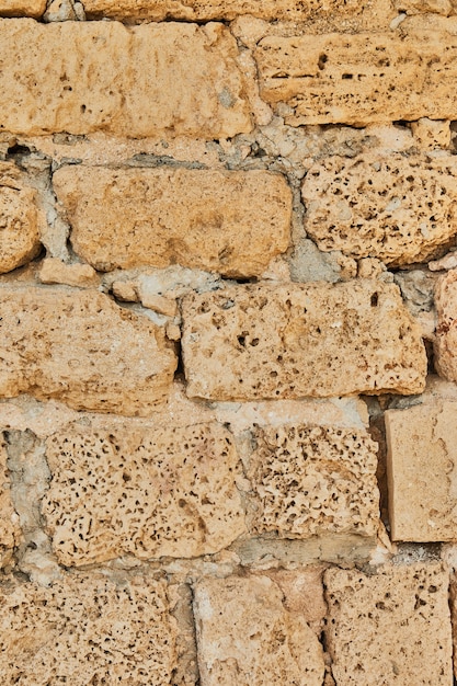 Achtergrond van de stenen muur van het kasteel gemaakt van stenen in verschillende vormen en maten en texturen.