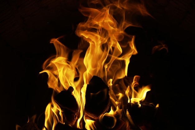 Achtergrond van de vlam in de oven Tongen van vuur in een bakstenen open haard Vuurtextuur