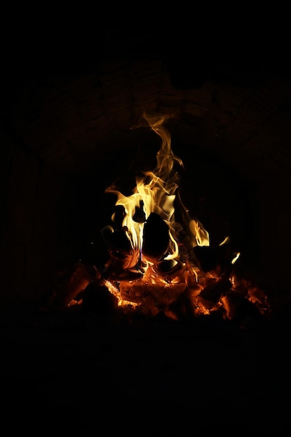 Achtergrond van de vlam in de oven Tongen van vuur in een bakstenen open haard Vuurtextuur