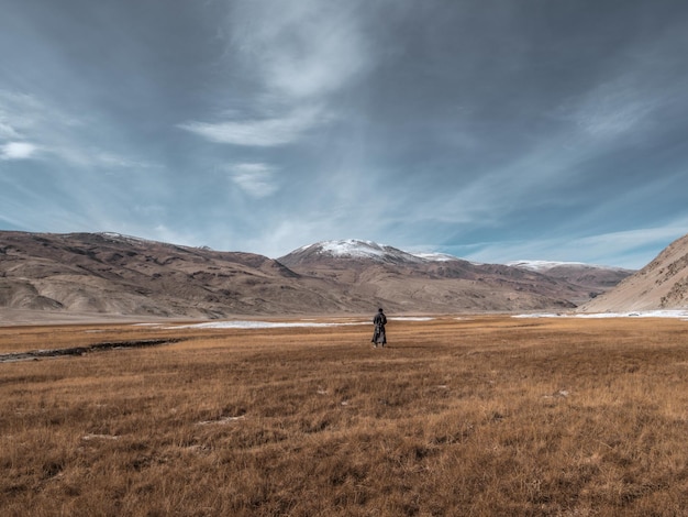 Achtergrond van een jonge man die op het landschap tegen de lucht loopt