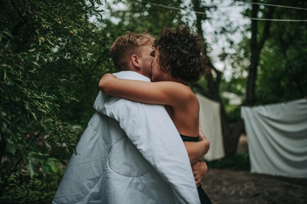 Foto achtergrond van een koppel dat zoent tegen bomen