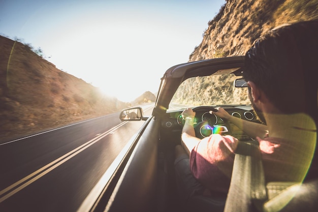 Foto achtergrond van een man die een auto rijdt tegen de lucht