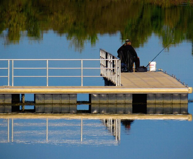 Foto achtergrond van een man die op een pier aan het vissen is